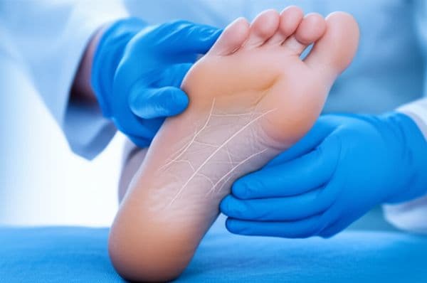 Person holding their foot while experiencing nerve-like pain