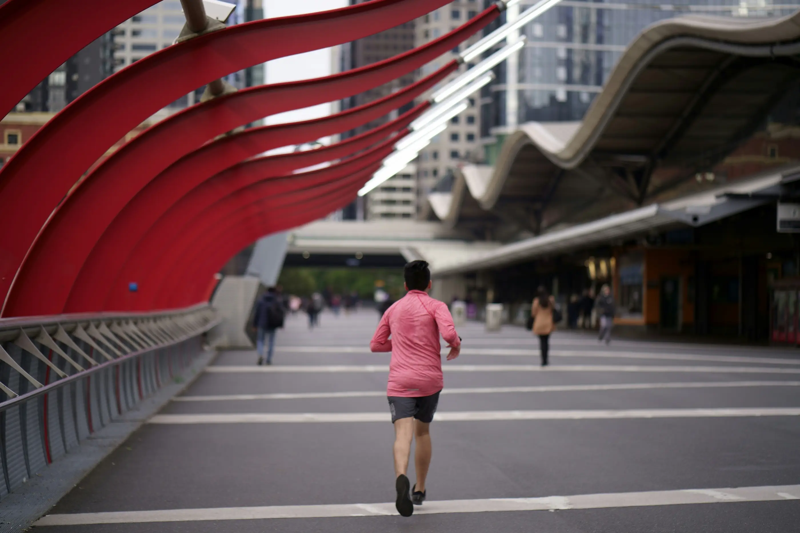 Runner jogging along a Melbourne city bridge