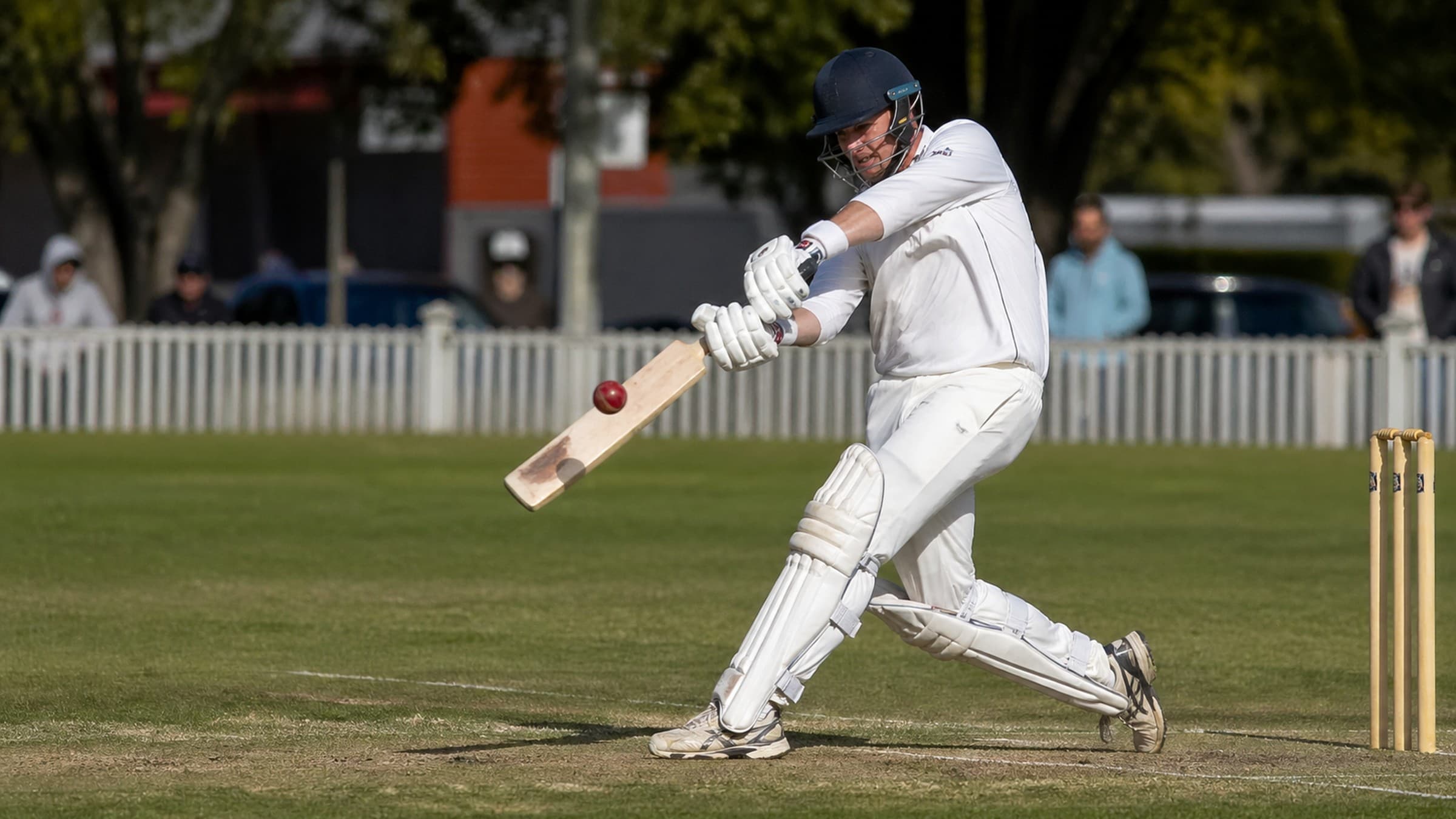 Cricket batsman playing a shot on pitch