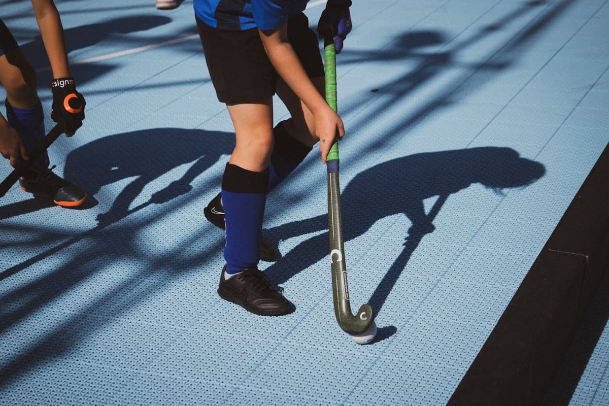 Field hockey players with sticks on synthetic turf