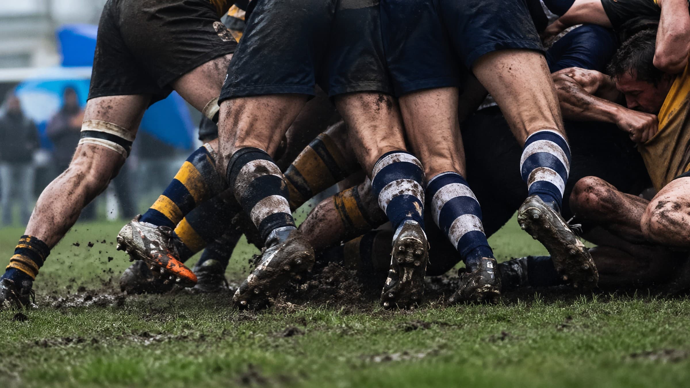 Rugby players boots on muddy grass field