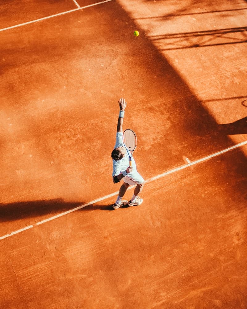 Tennis player preparing to serve on court